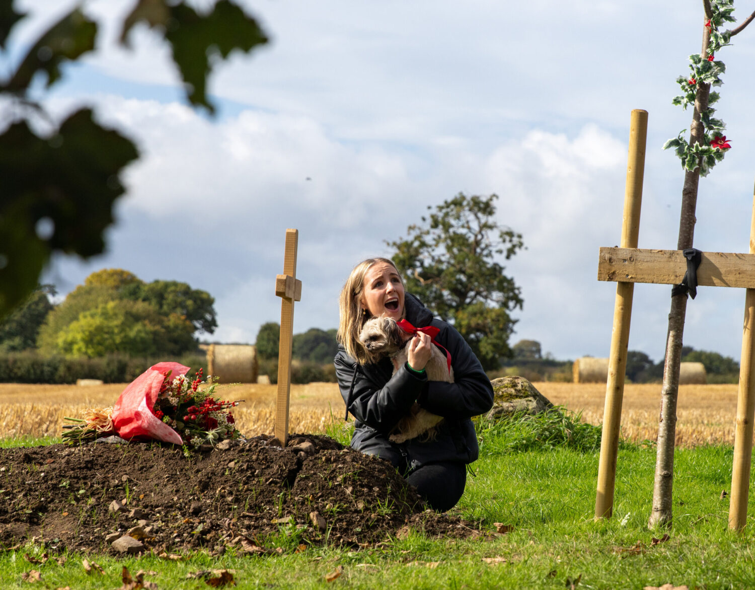 Belle holding Piper at the grave