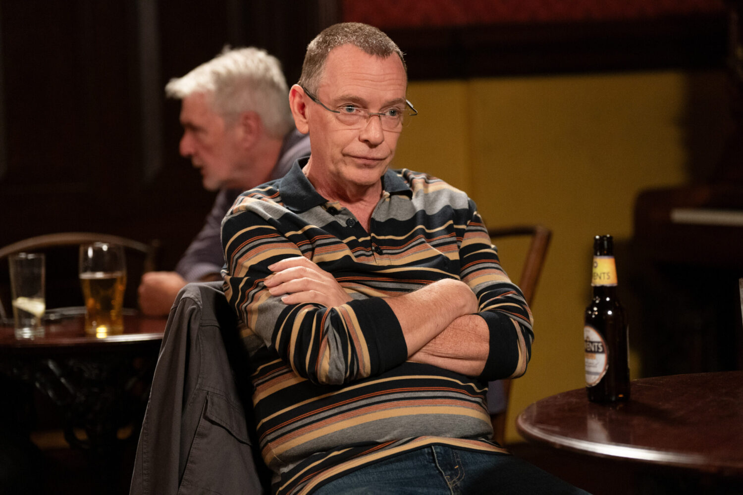 Ian looks miserable, arms folded in the pub