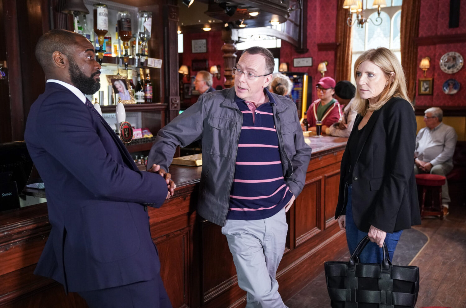 Junior shakes Ian's hand in The Vic with Cindy looking on in EastEnders