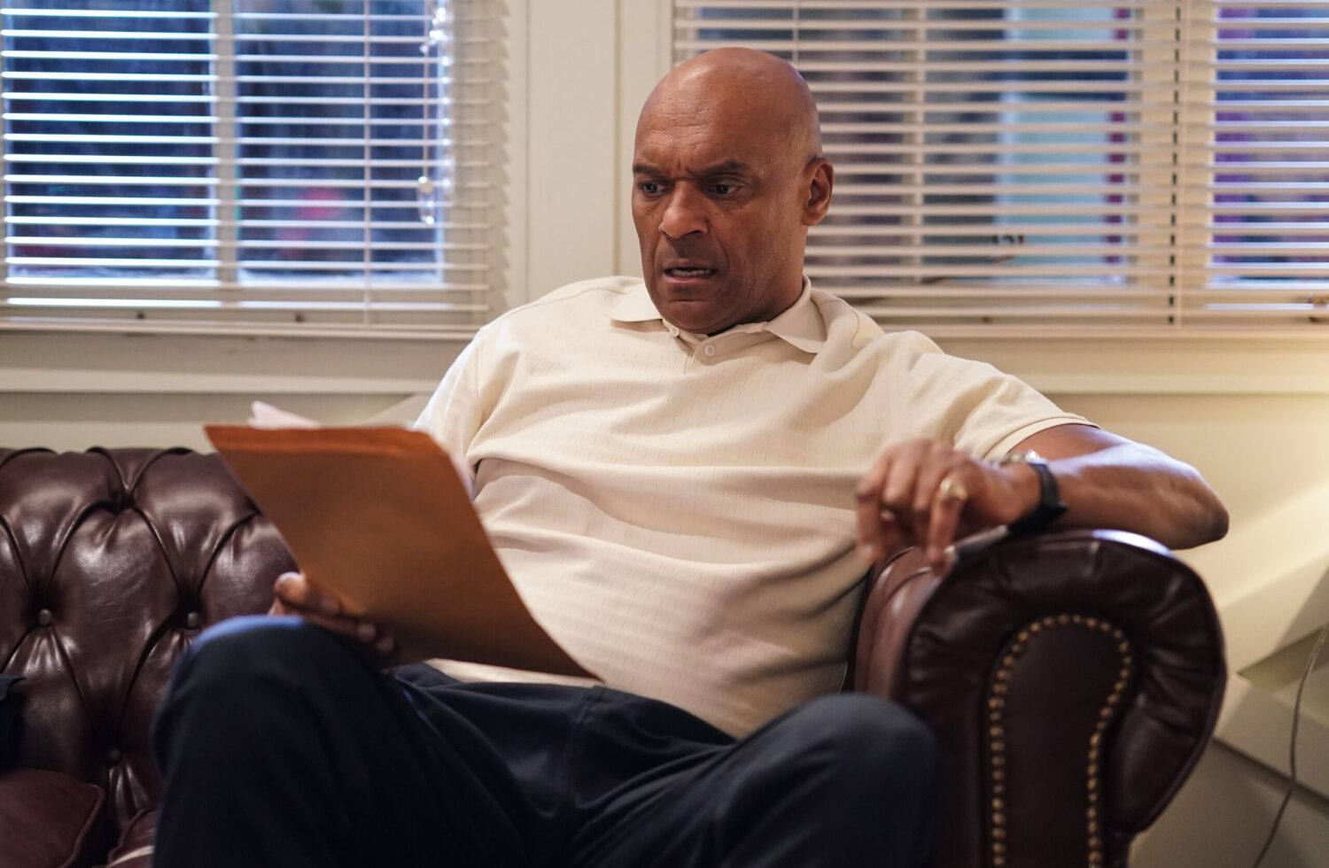 George is serious whilst reading a piece of paper