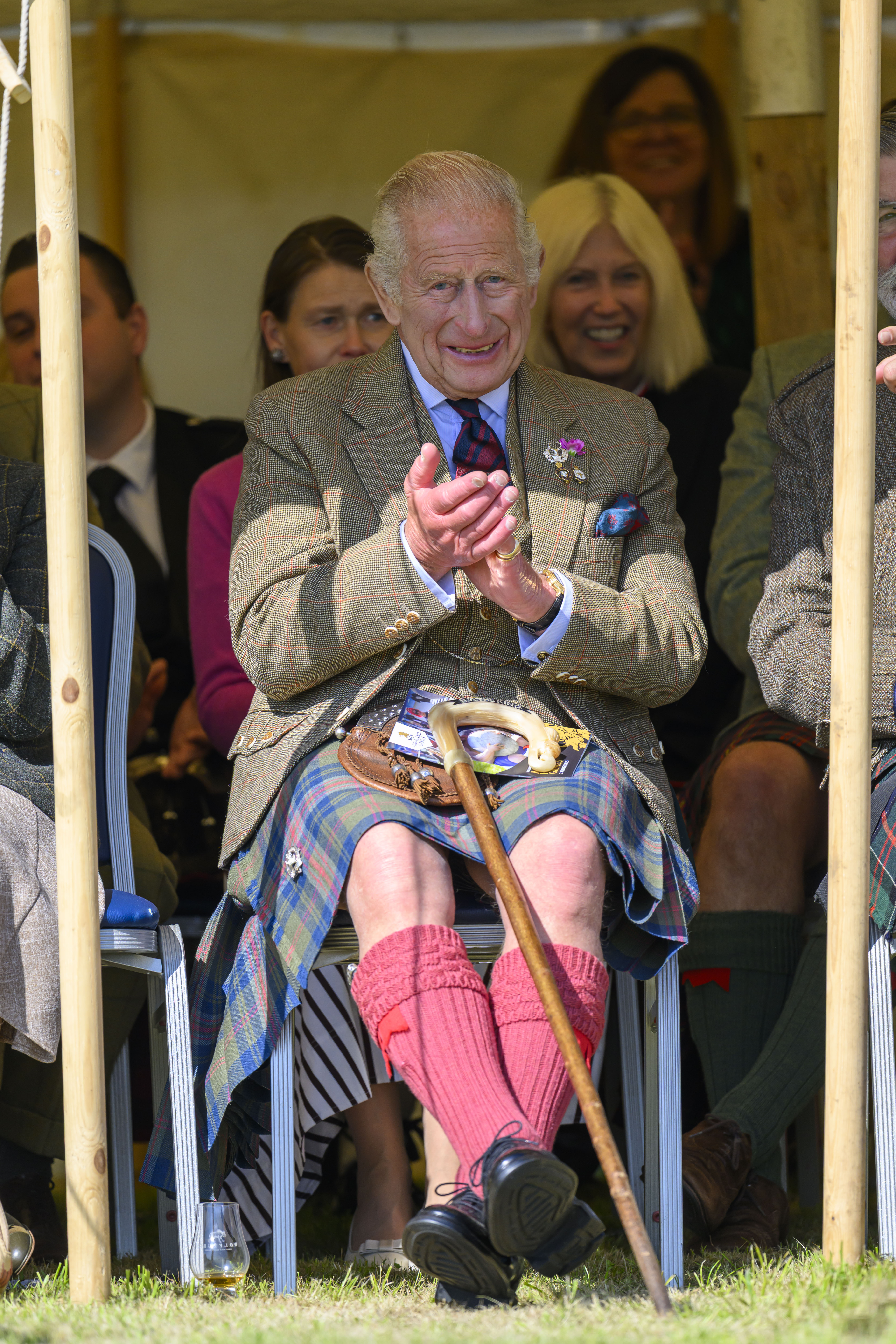 King Charles sitting and clapping at Highland Games
